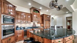 A kitchen with wooden cabinets, stainless steel appliances, a granite countertop, and a ceiling fan. - Lakefront - Unbelievable 3 levels w/Elevator! (Dandridge)