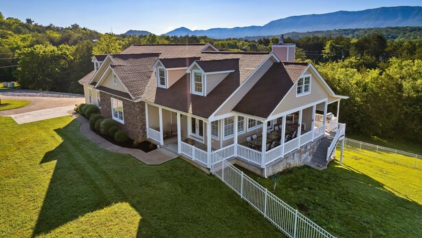 A large house with multiple levels, a covered porch, and a well-maintained lawn. - Lakefront - Unbelievable 3 levels w/Elevator! (Dandridge)