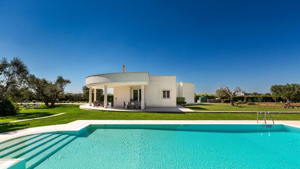 A modern house with a swimming pool in front.