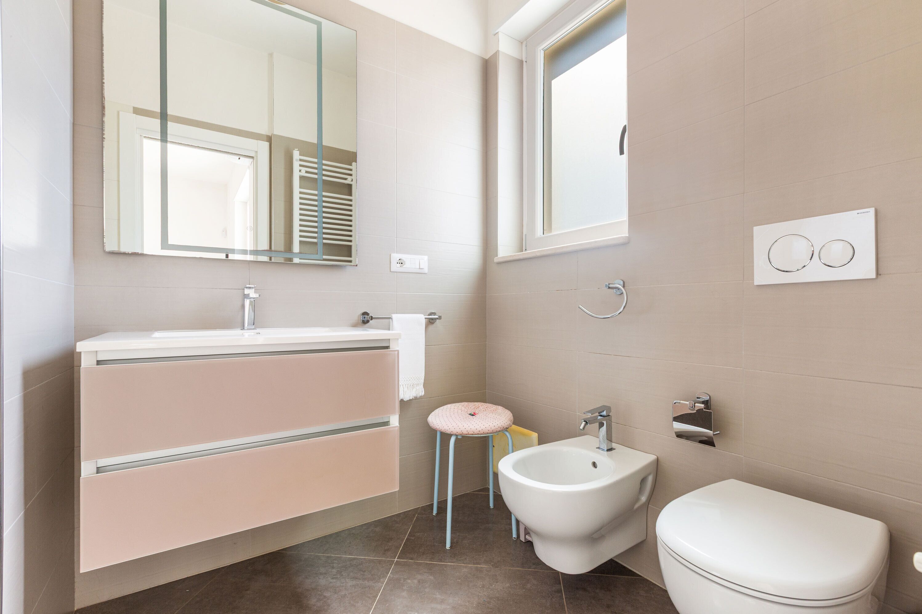Une salle de bain moderne équipée d’un meuble-lavabo, d’un bidet et de toilettes.