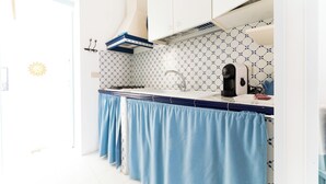 A kitchen with white cabinets, a blue countertop, and a patterned backsplash. - Jewel within walking distance of the CENTER (Favignana)