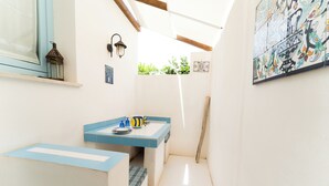 A narrow hallway with a blue countertop, a wall-mounted lantern, and a tiled backsplash. - Jewel within walking distance of the CENTER (Favignana)
