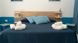 A neatly made bed with blue bedding, two pillows, and towels on either side. - Jewel within walking distance of the CENTER (Favignana)