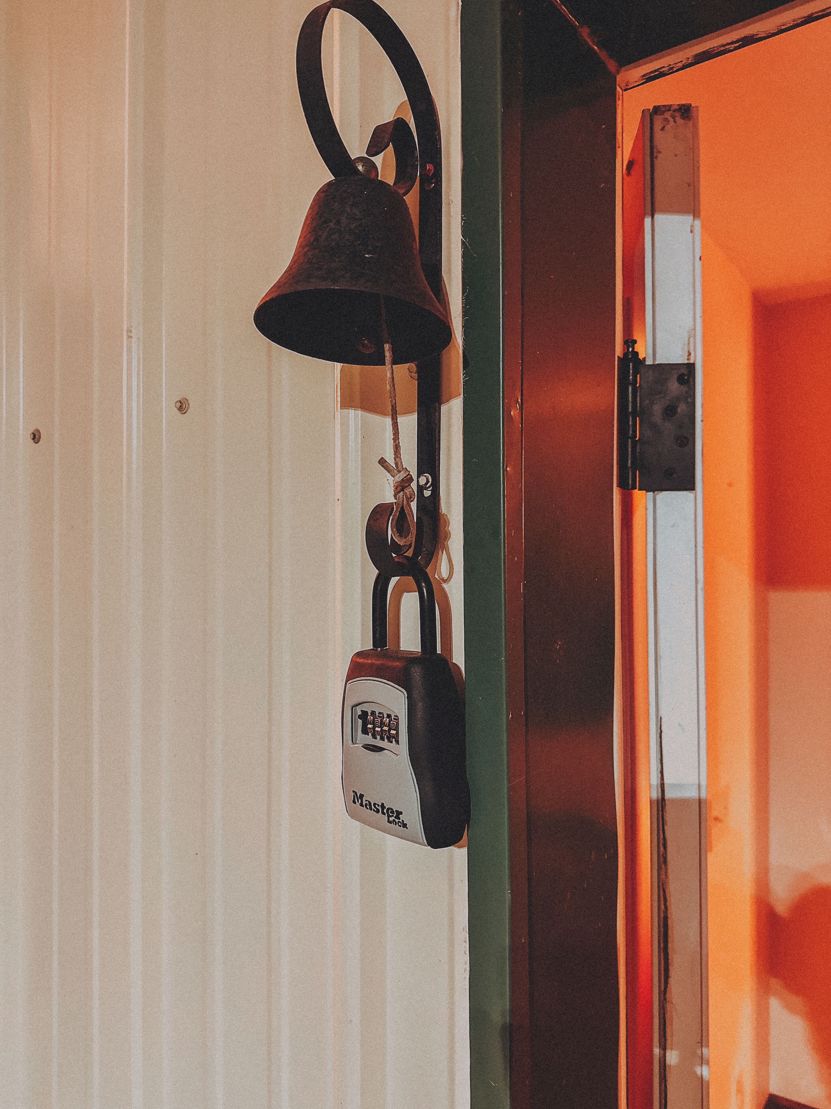 A door with a padlock hanging on a hook.
