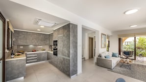 Una cocina moderna con armarios grises, horno empotrado y una isla central.