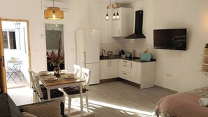 A compact living space with a dining area, kitchenette, and a bed. - Antonio Parra II Tourist Apartments (Jerez de la Frontera)