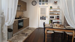 Una cocina con armarios de madera, una estufa y un comedor con mesa y sillas.