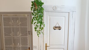 Una puerta con un letrero que dice 'TOILETTES' y una planta colgante.