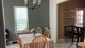 A dining area with a striped tablecloth, wooden chairs, and a chandelier. - CHARMING 3-BEDROOM HOUSE/ A ROOM FOR RENT, with WiFi, AC in lovely Cleveland. (Cleveland)