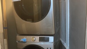 A stacked washer and dryer unit in a laundry room. - CHARMING 3-BEDROOM HOUSE/ A ROOM FOR RENT, with WiFi, AC in lovely Cleveland. (Cleveland)
