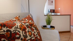 Quarto com cama, escrivaninha e planta em vaso.