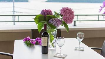 Ein Tisch mit einer Weinflasche, einem Glas und einer Blumenvase.