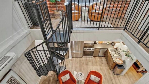 Un interior moderno con una escalera, una zona de cocina y asientos.