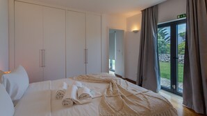 A hotel room with a large bed, a wardrobe, a mirror, and a sliding glass door to the outside. - BeGuest Penedo Escape Sea Suite 3 (Ulgueira)
