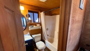 A compact bathroom with a toilet, sink, and bathtub. - The Shack #4                . (Williams)