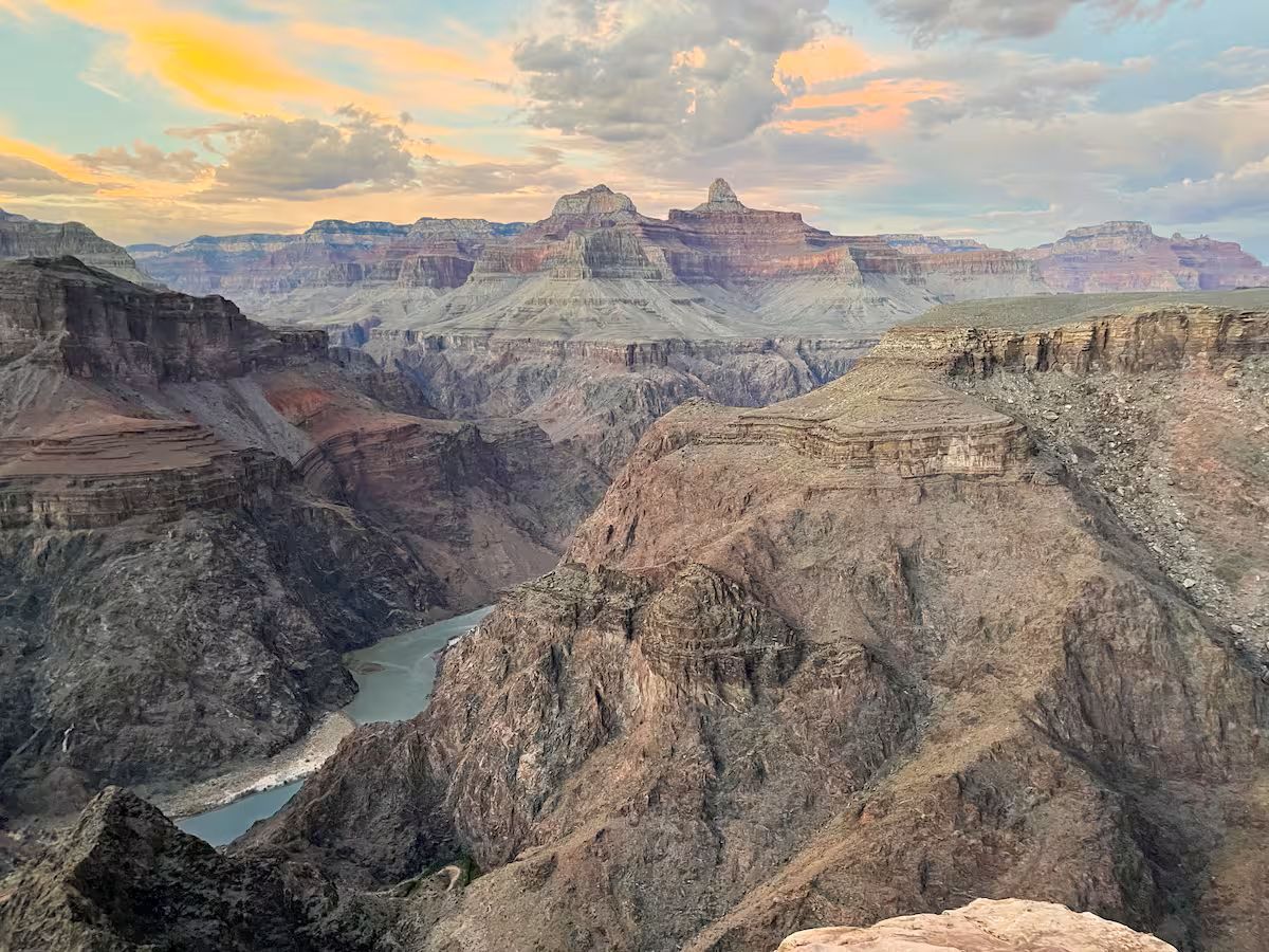 A canyon landscape with layered rock formations and a river.