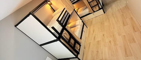 A compact room with a bed, a small table, and a chair.