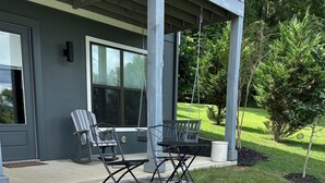 A patio area with a fire pit, two rocking chairs, and a table.