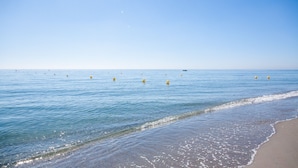 Een strand met helderblauw water en een zandstrand.