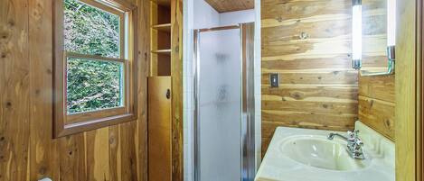 Een douche, handdoeken, zeep, toiletpapier