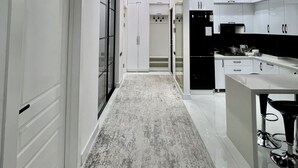 A modern kitchen with white cabinets, a central island, and pendant lighting. - Bibigon 31 (Tashkent)