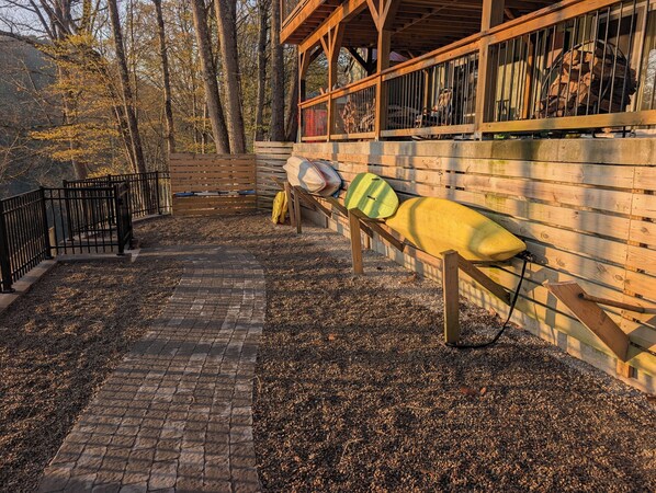 A wooden deck with a bench and a pile of firewood.