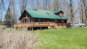 Une cabane en rondins avec un toit végétalisé, une terrasse et un petit porche.