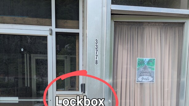 A building with a lockbox near the entrance, a restaurant door to the left, and an apartment door to the right. - Train View a spacious 3-bedroom upstairs apartment with WiFi in Northfork (Northfork)