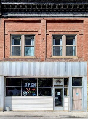 A two-story building with a brick facade, large windows, and a garage door.