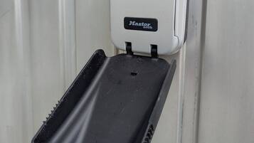 A Master Lock combination padlock on a white door.