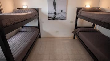 A room with bunk beds, a poster on the wall, and a tiled floor.
