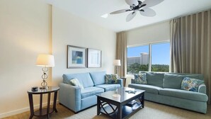Ein modernes Wohnzimmer mit zwei Sofas, einem Couchtisch und einem Deckenventilator.