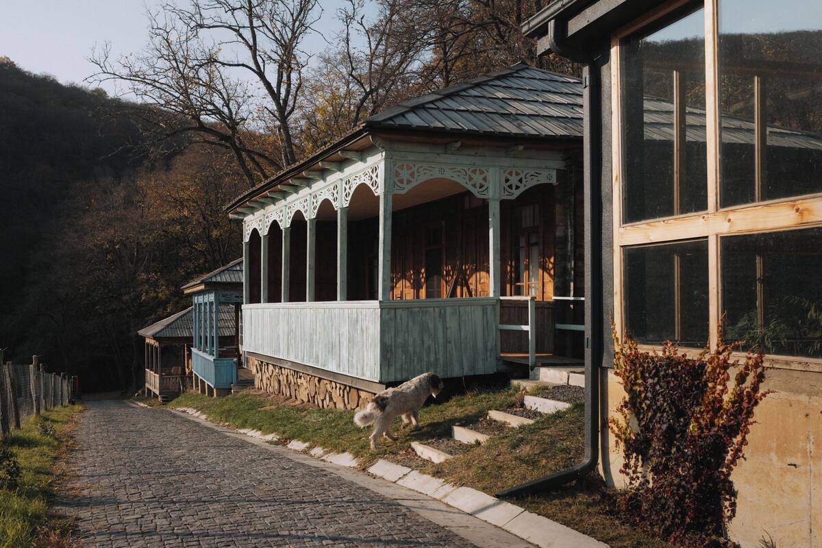 Un edificio rústico de madera con un porche y ventanas grandes.