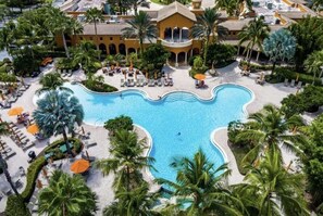 An aerial view of a resort with a large pool, palm trees, and a building with a yellow facade. - 3Bedroom 2.5 bath townhome in beautiful Naples Florida

: (Naples)