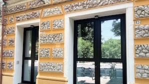 A building facade with stone paneling and numbered doors, likely indicating hotel rooms. - La Campanula (La Spezia)