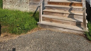 A two-story house with a front porch, wooden steps, and a white door. - Ninth Door Mention Apt 13 Main St. Milbridge (Milbridge)