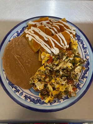 A plate with nachos, a tortilla, and scrambled eggs. - OYO Adhoc Barrio Antiguo (Monterrey)