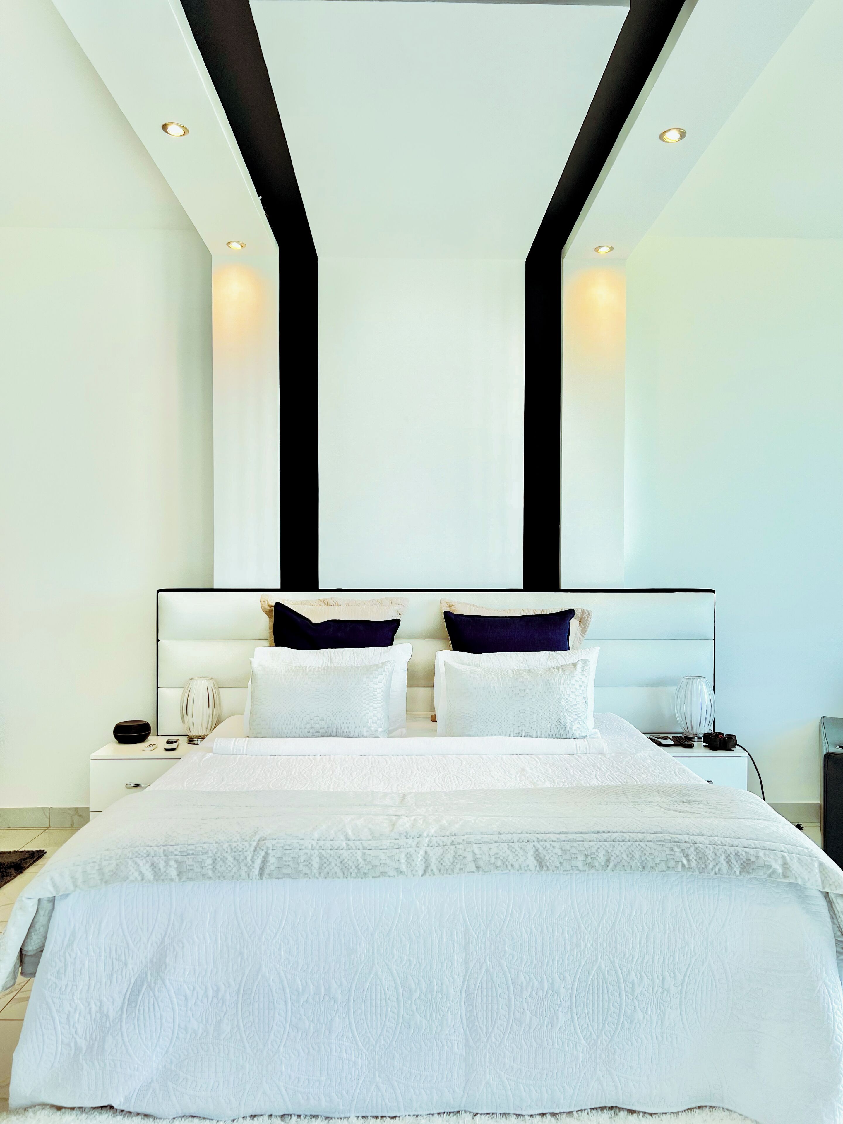 Un dormitorio moderno con una cama grande, dos mesitas de noche y una mesilla.