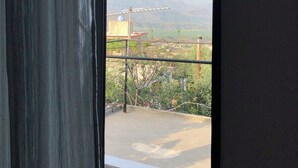 Un balcón con vista a montañas distantes y cielo despejado.