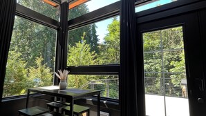 Une pièce dotée de grandes fenêtres, d’une lucarne et d’une table avec des chaises.