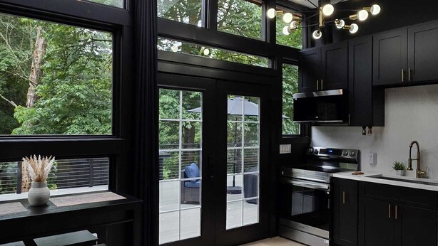 Une cuisine moderne dotée de grandes fenêtres, d’un coin repas et d’une lucarne.
