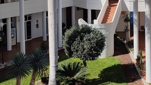 A multi-level building with a central staircase, surrounded by palm trees and a well-maintained lawn. - Echeide: A cozy retreat in Costa Adeje with breathtaking views (Costa Adeje)