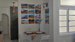 A compact kitchen with a dining area, a coffee machine, and a wall-mounted light fixture. - Echeide: A cozy retreat in Costa Adeje with breathtaking views (Costa Adeje)