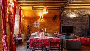 A cozy dining area with a wooden table set for four, surrounded by chairs. - Holiday home 6 bedrooms, pool table, sauna, and foosbal (Le Mont-Dore)