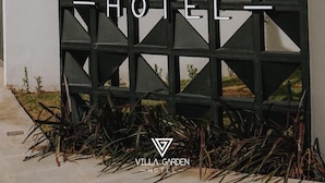 A sign for Villa Garden Hotel with a geometric design and a logo. - Hotel Villa Garden Janaúba (Janauba)