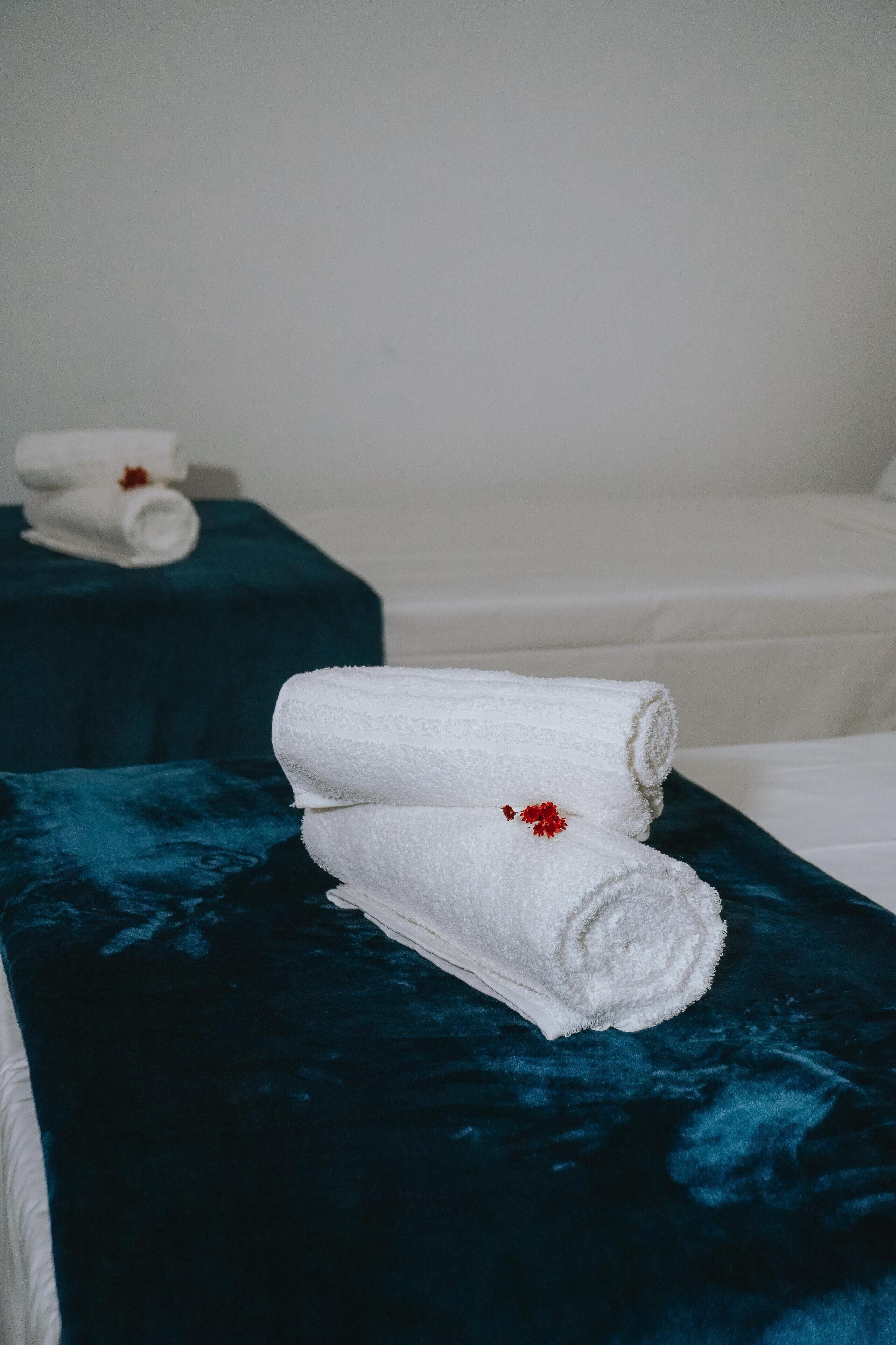 A hotel room with two beds, each with a dark blue headboard and white linens.