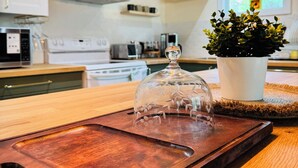 Una cocina con encimera de madera, estufa y una planta en maceta.