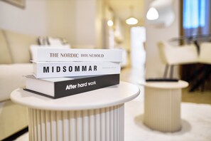 Una pila di libri su un tavolo bianco in una stanza moderna, ben illuminata e dal design minimalista.