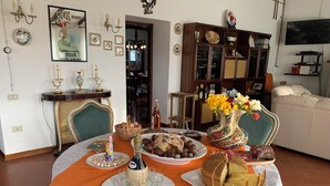 Un coin repas avec une table mise pour le repas, un canapé et un téléviseur en arrière-plan.