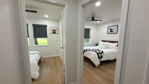 A bedroom with a bed, a ceiling fan, and a window with a view of greenery. - Welcome to your perfect getaway or family retreat in beautiful Magnolia Texas ! (Magnolia)